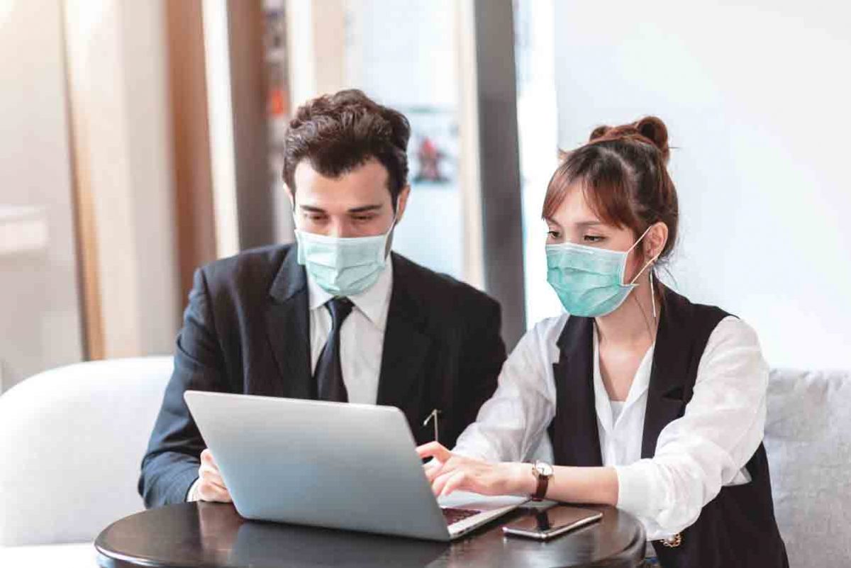 duas pessoas trabalhando, simbolizando plano de contingenciamento contra covid-19